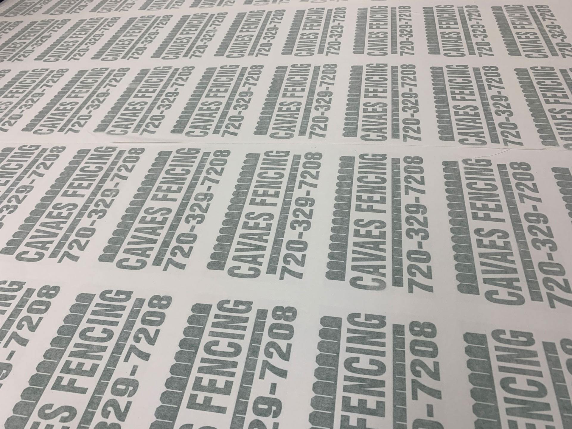 Sheet of bulk-printed gray Cavaes Fencing custom fence signs with phone number 720-329-7208