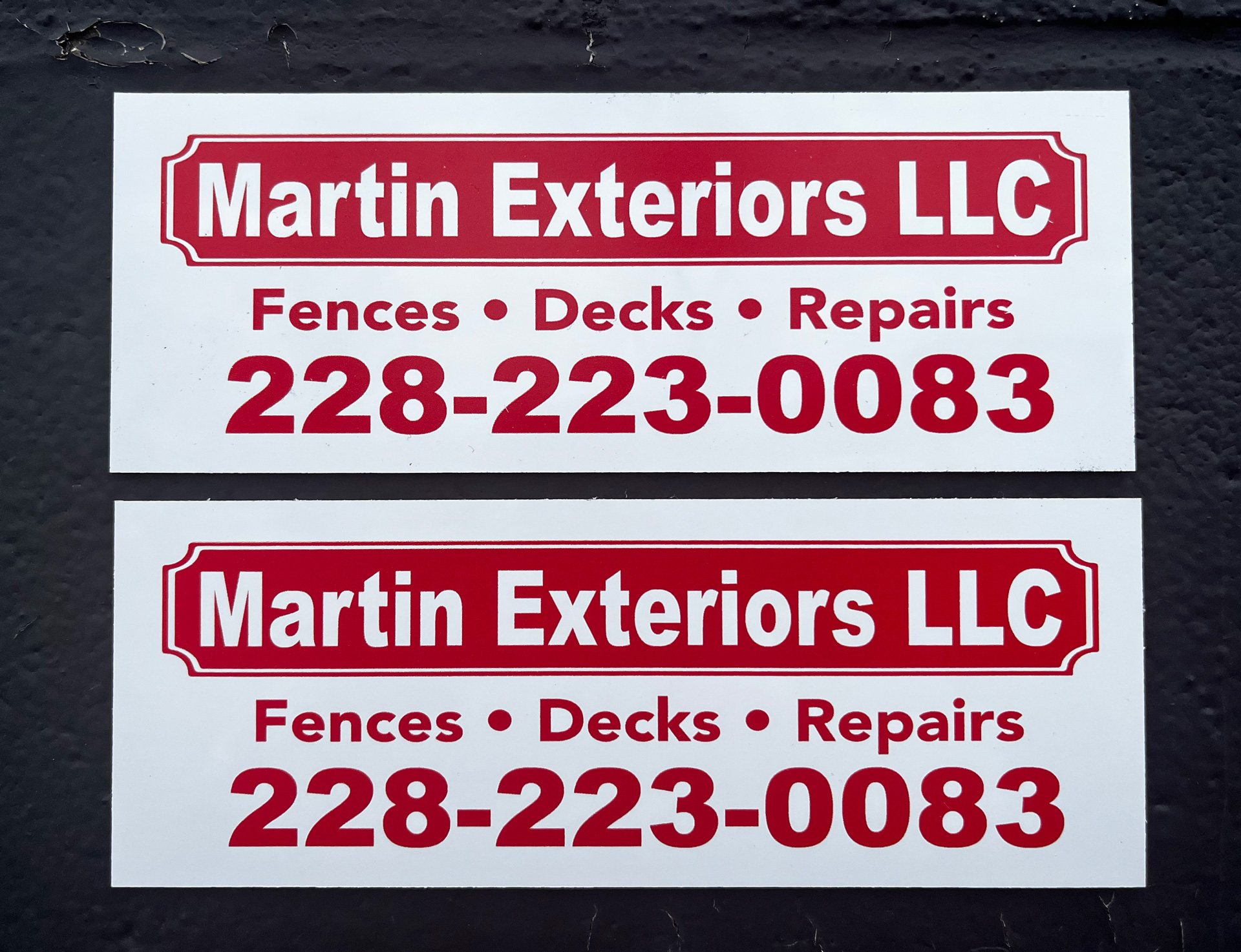 Two white and red custom fence signs for Martin Exteriors LLC — Fences, Decks, Repairs — with phone number 228-223-0083