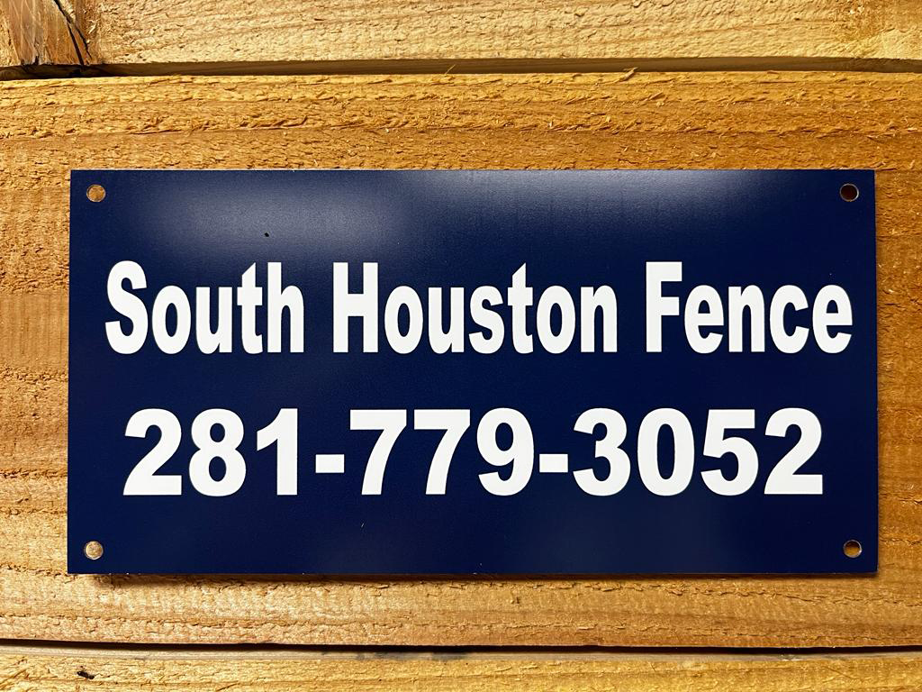 Navy blue South Houston Fence custom sign with white text and phone number 281-779-3052 mounted on a cedar wood fence